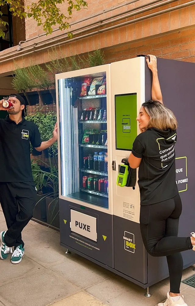Equipe SmartBox se divertindo em frente à máquina