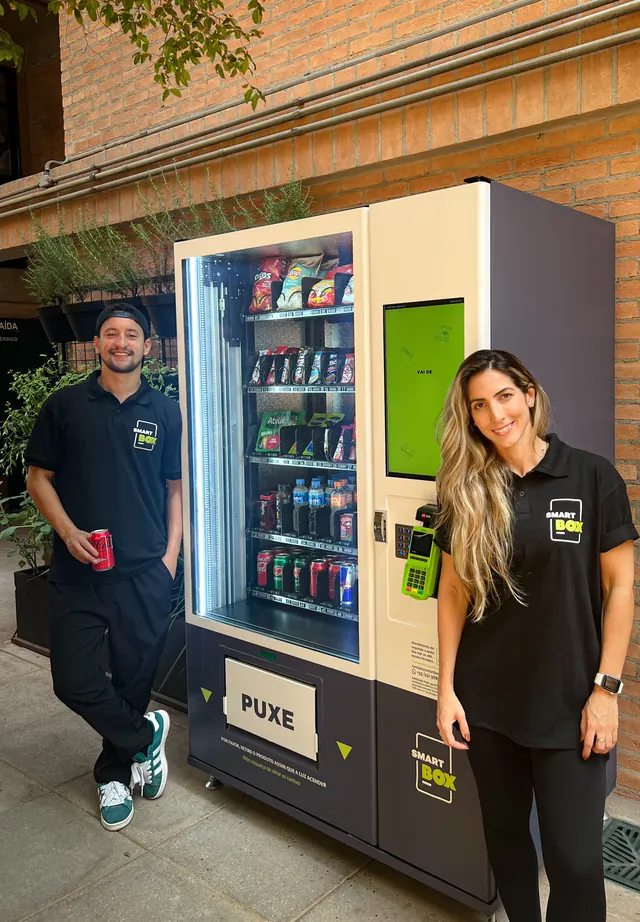 Equipe SmartBox ao lado de uma vending machine