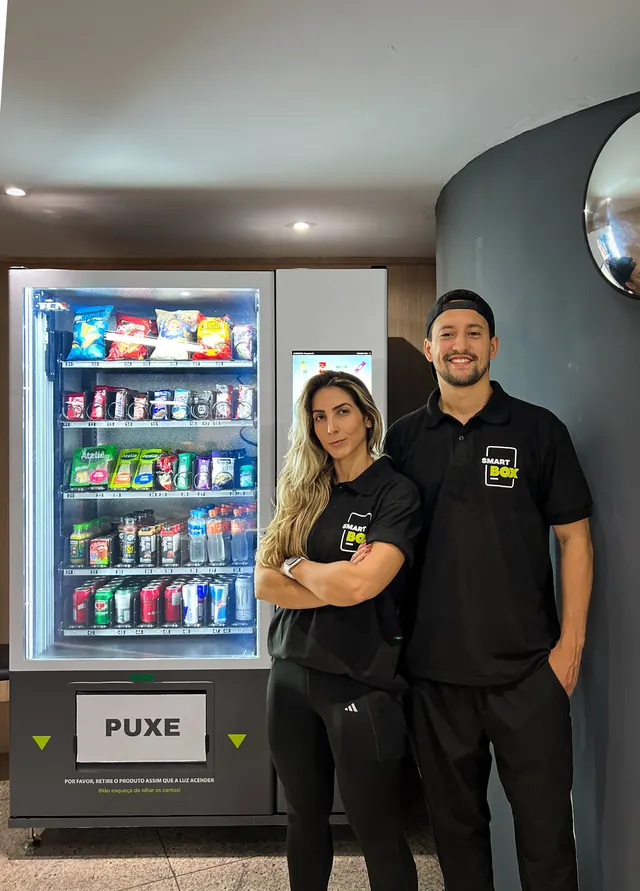 Equipe SmartBox em frente a uma vending machine no lobby de um prédio corporativo