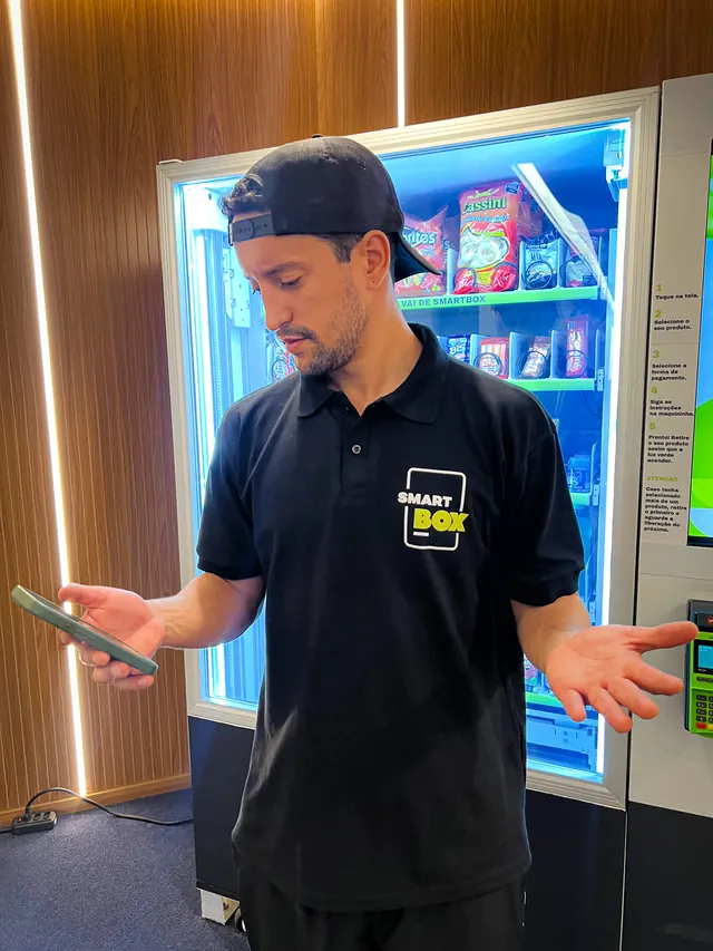 Colaborador da SmartBox em frente à vending machine