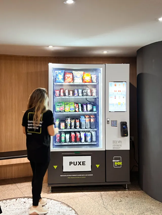 Colaboradora em frente à vending machine SmartBox