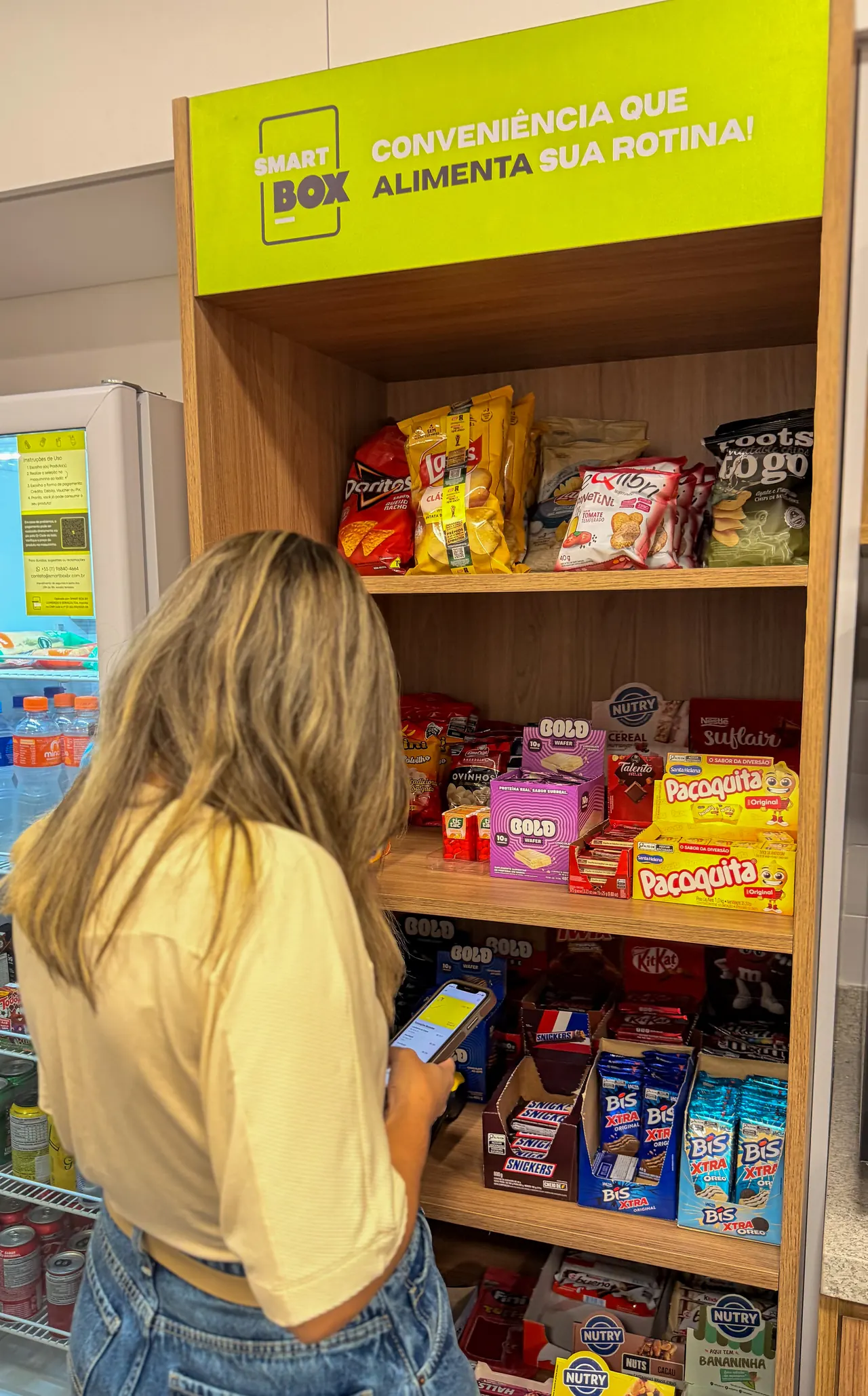 Colaboradora pagando pelo celular no minimercado SmartBox